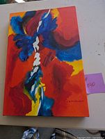 Front view of colorful abstract painting on canvas signed by Lola Welwood, featuring bold reds, blues, and yellows.