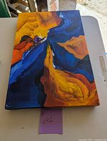 Front view of the abstract painting showing vibrant colors and artist signature.