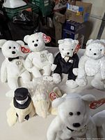 Six pairs of Ty Beanie Babies wedding couples displayed on table with tags attached.