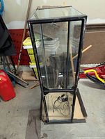 Angle view of rectangular glass fish tank with black frame, showing clear glass panels and the top frame.