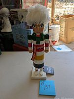 Front view of Hudson's Bay nutcracker figurine on table with fur hat and colorful striped outfit