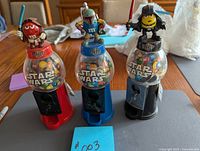 Photo showing the 3 Star Wars themed M&M dispensers: Red M&M Sith, Blue M&M Boba Fett, Yellow M&M Darth Vader, in red, blue and black bases, respectively.