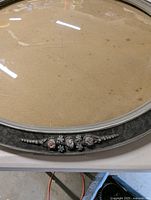 Front view showing beveled glass, decorative floral detail on the wooden frame in muted gray color.