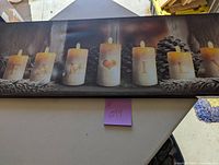 Frontal view of canvas showing candles with letters F, A, M, heart, I, L arranged among pinecones.