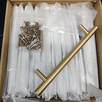 15 solid brass handles individually wrapped, with a small bag of screws placed on top