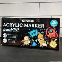 Box packaging of PNPEKT 26 color dual-tip acrylic markers showing product branding, dual tip info and colorful cartoon design.