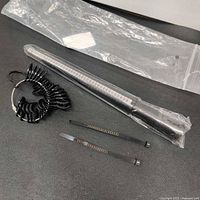 All four ring sizing tools visible, including ring mandrel, two black metal sizers, and plastic ring gauge keyring.