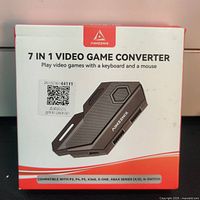 Front of the sealed product box showing brand name AIMZENIX, product image, and compatibility information with PS3, PS4, PS5, Xbox 360, Xbox One, Xbox Series X/S, and Nintendo Switch.