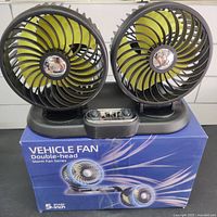 Front view showing two yellow 5-inch fans in black cages, control panel with knobs and USB ports, and fan base on original packaging box.