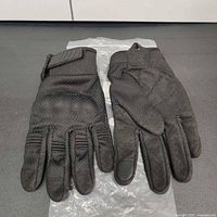 Photo of the gloves showing palm side with grippy, textured surface and perforations.