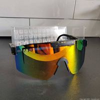 Front view of polarized Pit Viper sunglasses with multicolor mirrored shield lens and black frame with gold speckles.