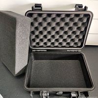 Open view of the flight case showing the convoluted foam padding in the lid and flat foam base insert removed from the case.