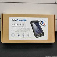 Closed box showing SoloForce branding and product summary including 20000mAh battery, wireless charging, solar powered, LED lantern and emergency lights.