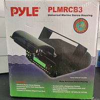 Box showing PYLE PLMRCB3 branding and product details with image of the housing and text describing features such as neoprene gasket seal and universal fit.