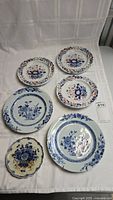 Overview of six antique decorative plates, three Spode identified with blue and orange floral designs, and three others with blue and white floral patterns including one smaller scalloped plate.