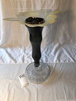 Front view of handmade glass plant stand/birdbath showing the flower-shaped top with decorative stones and clear patterned base.