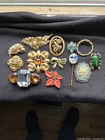 Top view of the brooch collection showing various styles and colors including floral, animal, and geometric designs.