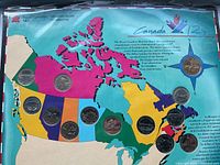 Wide shot of entire coin set mounted on colorful Canada map backing displaying twelve quarters and one gold-colored dollar coin.