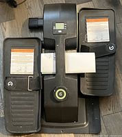 Top view of Cubii JR2 elliptical showing pedals, central console with LCD display, power button, and straps on pedals.