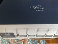 Box of 8 Mikasa Cheers stemless wine glasses showing the brand and product line on the box.