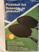 Photo of box front showing product name and image of two black pickleball paddles with wrapped handles.