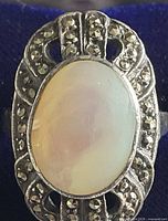 Close-up of the ring showing the oval mother of pearl stone surrounded by marcasite stones on sterling silver setting.