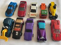 Overview of 10 vintage toy cars arranged in two rows, showing variety of colors and types.