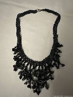 Full view of the 16-inch handmade black beaded choker necklace with bead fringe and hematite chips, showing the entire necklace laid flat.
