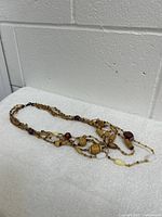 Full view of multi-strand beaded necklace showing bead variety and lobster claw clasp