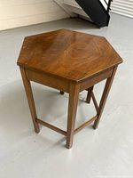 Full angled view of the wooden hexagonal table showing the top and leg structure