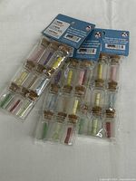 Three packaged glass bottles each containing colorful rolled paper scrolls secured with corks, displayed on a white background.