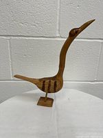 Photo of the wooden bird sculpture showing full profile and base mount