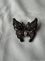 Top view of butterfly brooch showing intricate metalwork and multicolored stones