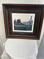 Full view showing the framed photograph, wall art with vintage dark wooden frame and floral decorations.