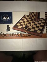 Box cover showing WE Games chess set branding and partial image of chessboard with pieces.