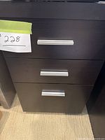 Front view of the wood office cabinet showing three closed drawers with silver pulls and a price tag.