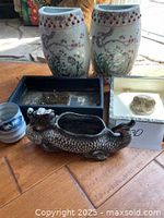 Full view of two painted ceramic vases, dragon planter, small blue and white flower pot, and two flower arranging shallow pots on wooden surface.