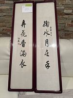 Two framed Chinese calligraphy art pieces side by side showing full view of frames and calligraphy.