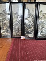 Four framed embroidered silk art pieces depicting Chinese mountain landscapes with calligraphy. Set laid out on floor showing overall condition.