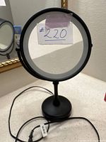 Front view of the mirror showing both standard reflective side and magnification side with paper label #220 taped on mirror glass.