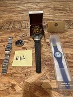 All items in lot including two wristwatches, cufflinks in open box, keychain, and gold-toned clip