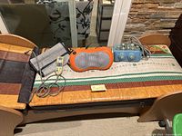 Wide shot showing wooden massage bed topped with patterned mat and all accessories arranged