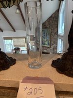 Front view of clear glass cylinder vase on mantle, shows height and shape.