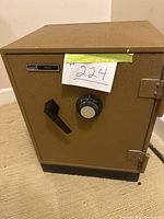 Front view of vintage Montgomery Ward safe showing brown textured finish, dial combination lock, and handle