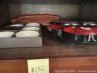 Wooden leaf tray, boxed appetizer bowls, and black and red lazy susan trays on a wooden surface.