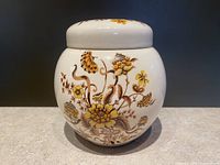 Full view of Sadler ginger jar showing front floral design with brown and golden yellow flowers and lid