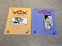 Two Vox Narrative Quarterly magazines side by side on carpet, Fall 2000 yellow cover and Winter 2001 blue cover