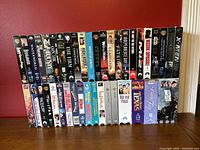 Photo showing 46 VHS tapes in their cases, titles visible include Waterworld, Gladiator, Independence Day, Star Wars, Termintor 3, X-Men, among others.