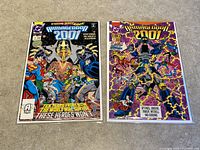 Two Armageddon 2001 comic books (issues #1 and #2) from DC Comics laid side-by-side on a floor, both bagged and boarded.