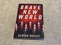 Front cover of Brave New World by Aldous Huxley paperback showing book title and embryo imagery.